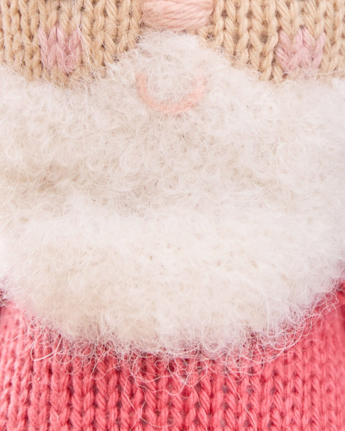 Baby Santa doll by Cuddle + Kind wearing a red jolly hat, soft plush toy with a cheerful expression and festive holiday attire.