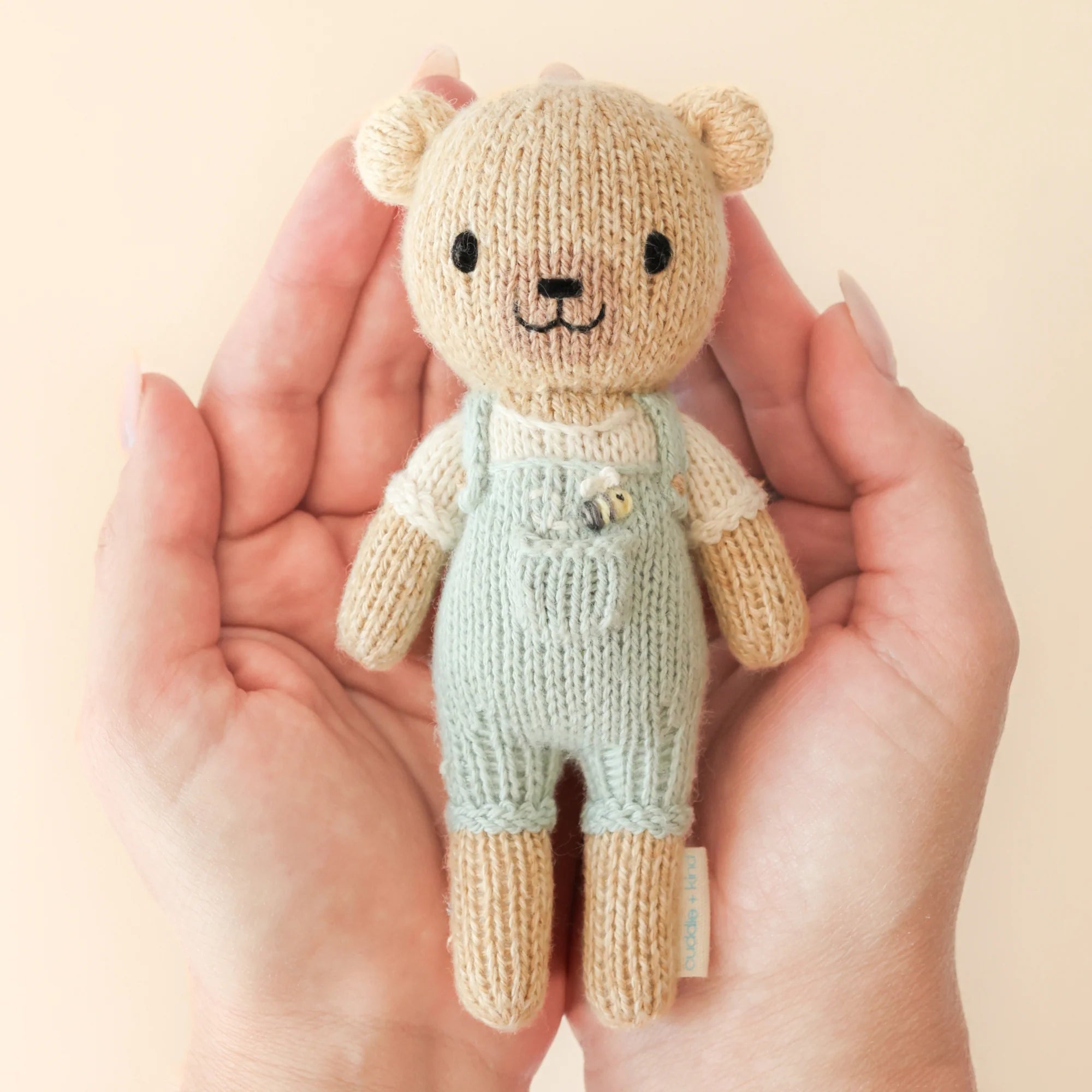 Tiny Charlie the Honey Bear plush toy by Cuddle + Kind, soft and cuddly stuffed bear with honey-inspired design.