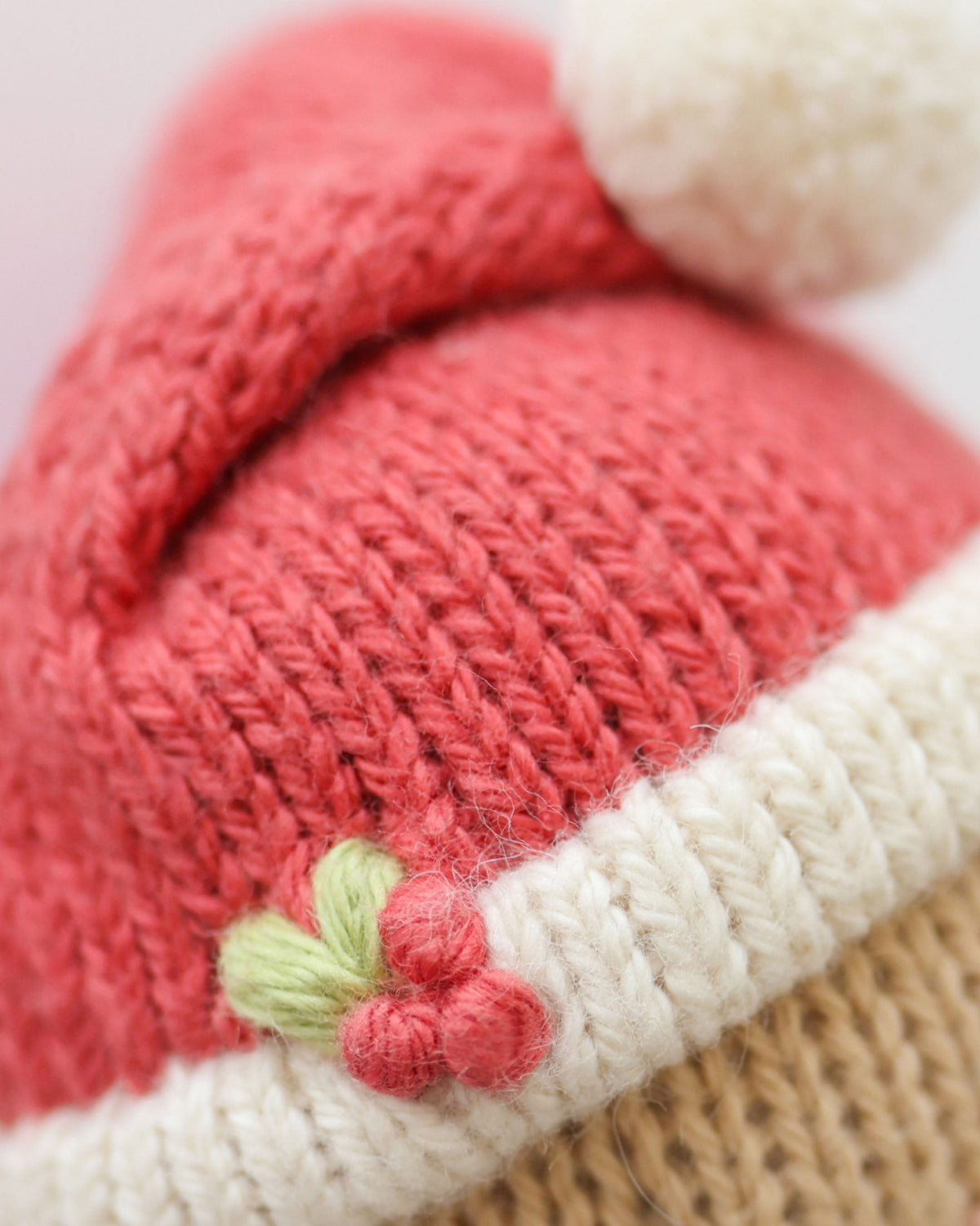 Soft plush Tiny Santa doll from Cuddle + Kind, featuring a red hat and festive outfit, perfect for holiday cuddling and decoration.