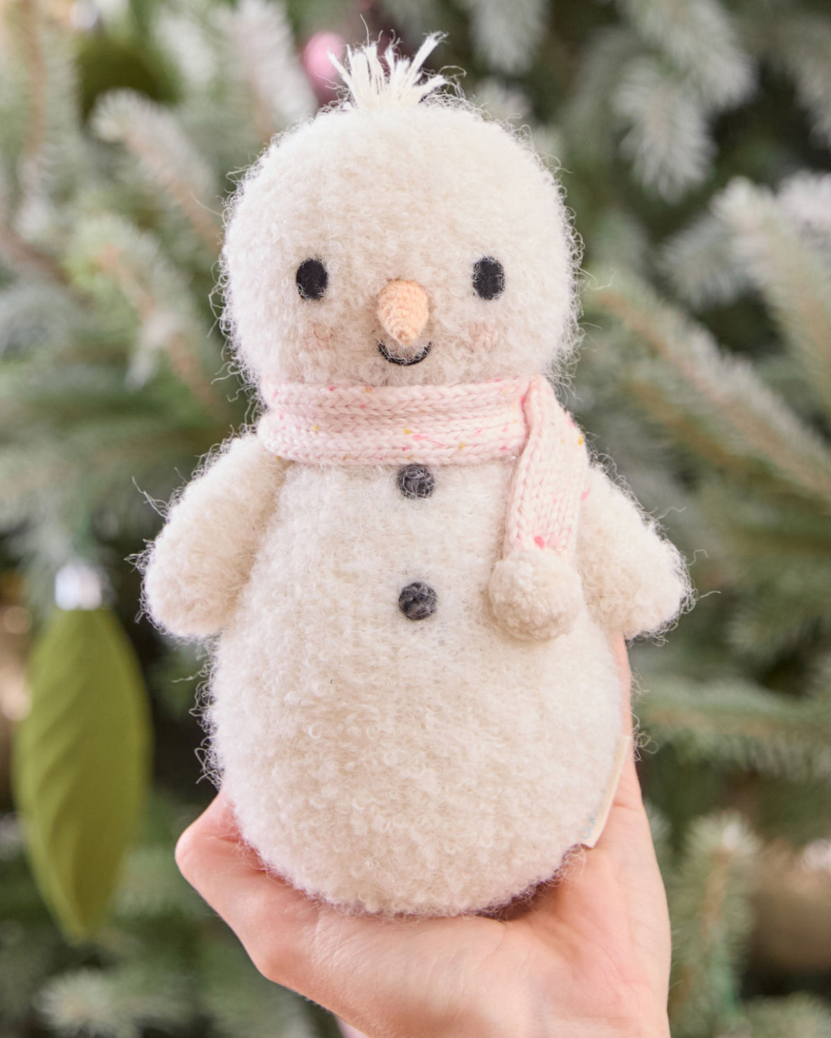 Baby Snowman plush toy by Cuddle + Kind with candy fleck pattern, soft fabric, and adorable snowman design for infants.