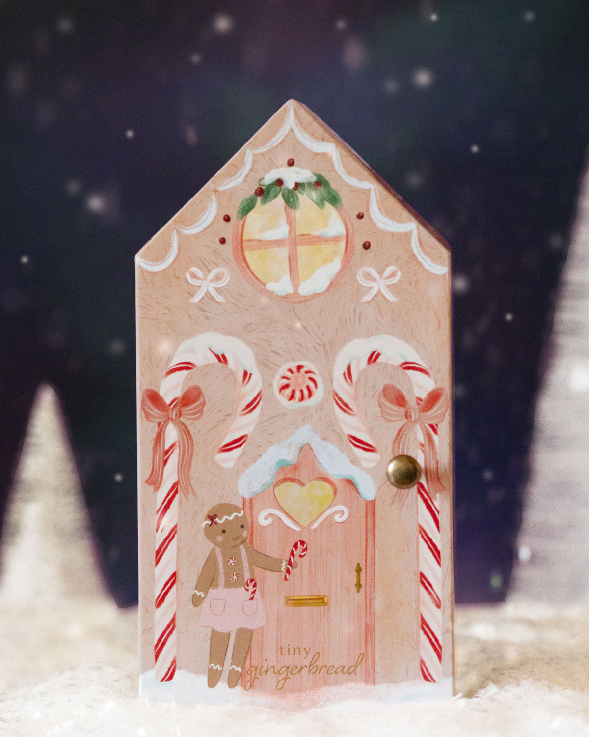 Tiny Gingerbread Sugarplum Girl doll by Cuddle + Kind, with soft fabric and detailed gingerbread design, close-up shot.