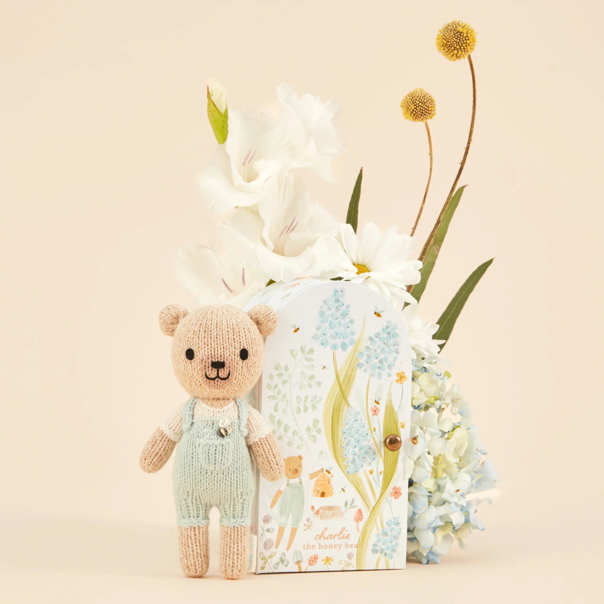 Tiny Charlie the Honey Bear from Cuddle + Kind, a small plush bear with soft, cuddly fur and honey-colored features.