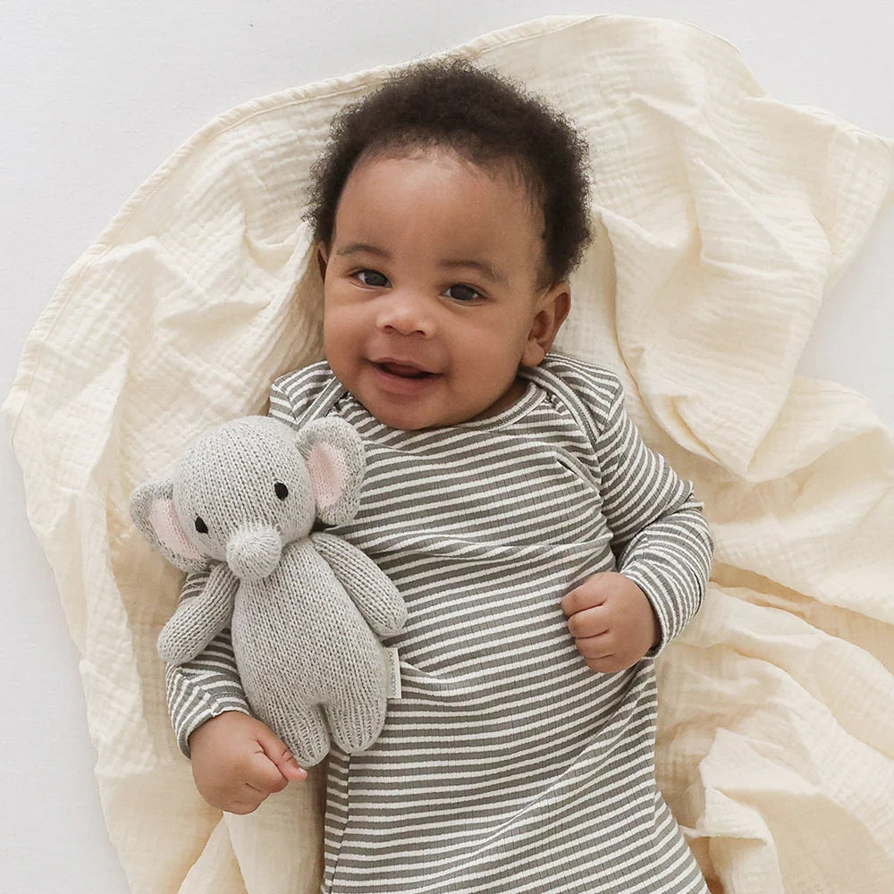 Soft Baby Elephant plush toy from Cuddle + Kind with gentle gray fur and embroidered facial features, perfect for cuddling.