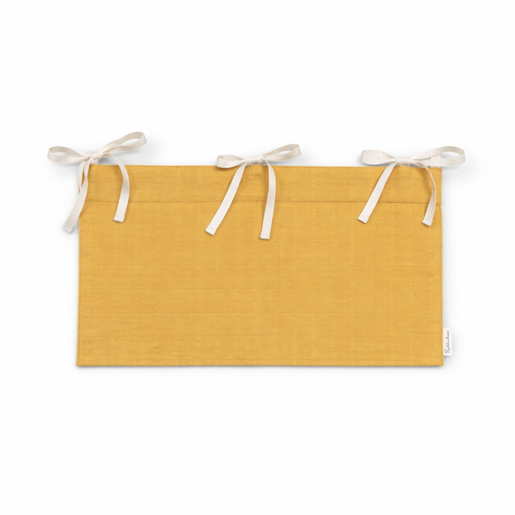 Bubbadue mustard muslin cot pocket attached to a nursery cot for storing essentials, soft and breathable fabric.