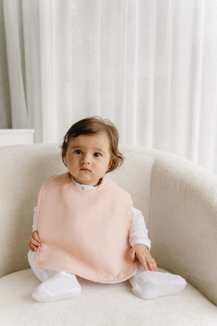 Bubbadue oversized pale blue feeding bib with waterproof material and adjustable neck closure, designed for baby feeding protection.