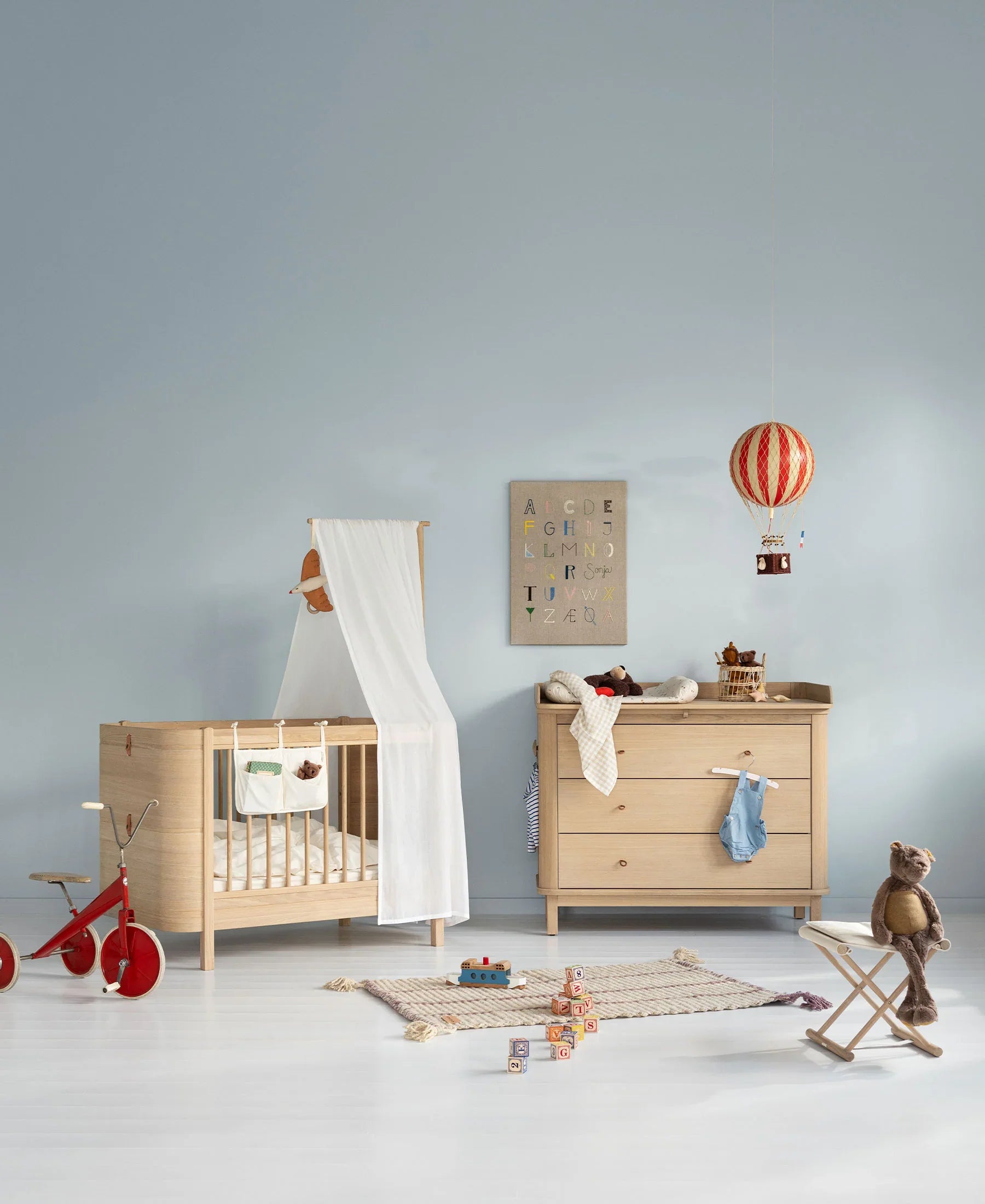Oliver Furniture Wood Mini+ Cot Bed with Junior Kit in oak, showcasing a sturdy wooden baby bed with adjustable features.