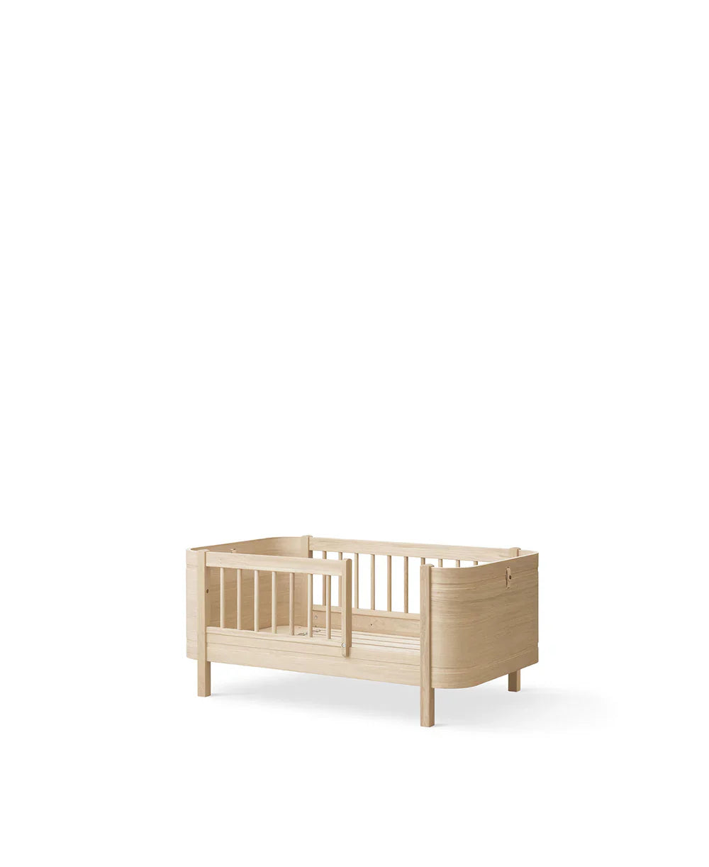 Oliver Furniture Oak Wood Mini+ Cot Bed with Junior Kit, showcasing a compact, stylish children's bed with natural wood finish.