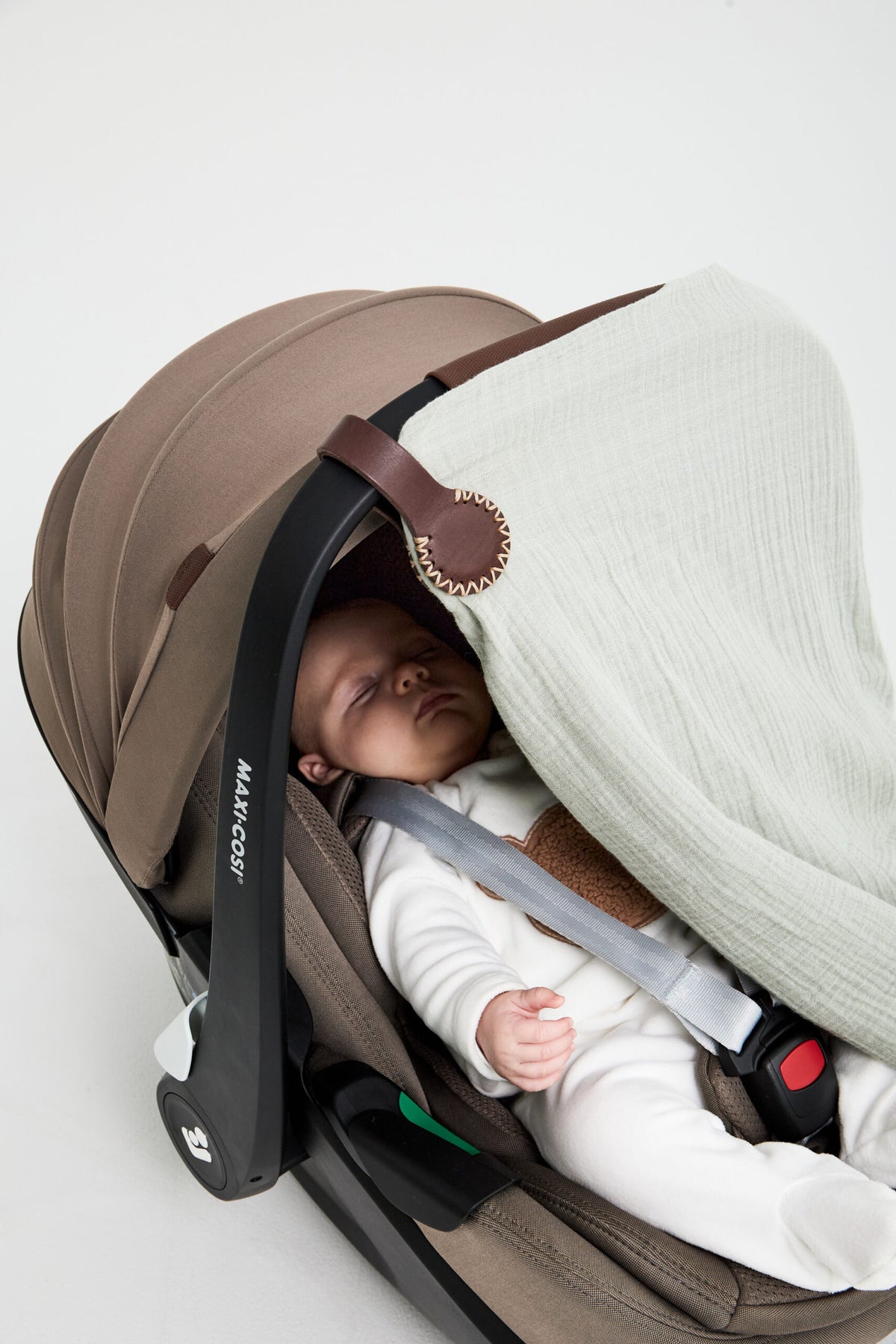 Constantia Mocha Stella Clip with cream stitching holding a muslin