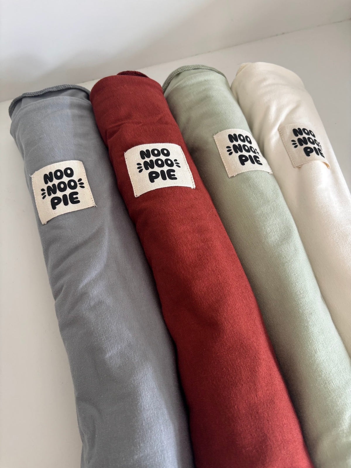NooNoo Pie Tie baby wraps rolled in Stone, Sienna, Sage and Ivory