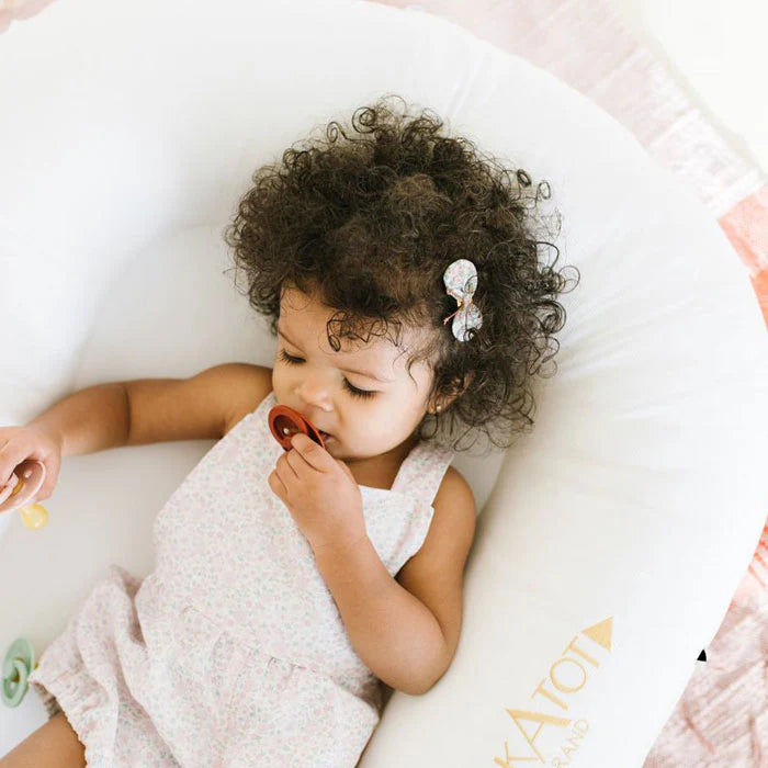Pristine white Dock-A-Tot Deluxe+ Baby Dock for 0-8 months, showing the soft, cushioned baby sleep surface with adjustable sides.