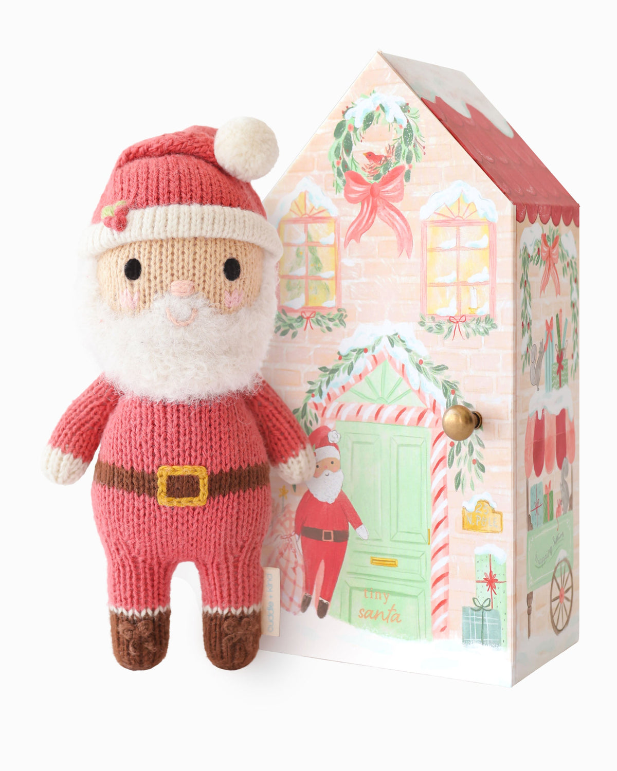 Soft Tiny Santa plush toy from Cuddle + Kind, featuring a red hat, white beard, and cozy winter outfit.