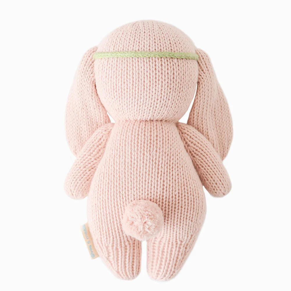 Back view of Cuddle + Kind Baby Bunny in rose with ivory floral design, soft plush toy for babies and young children.