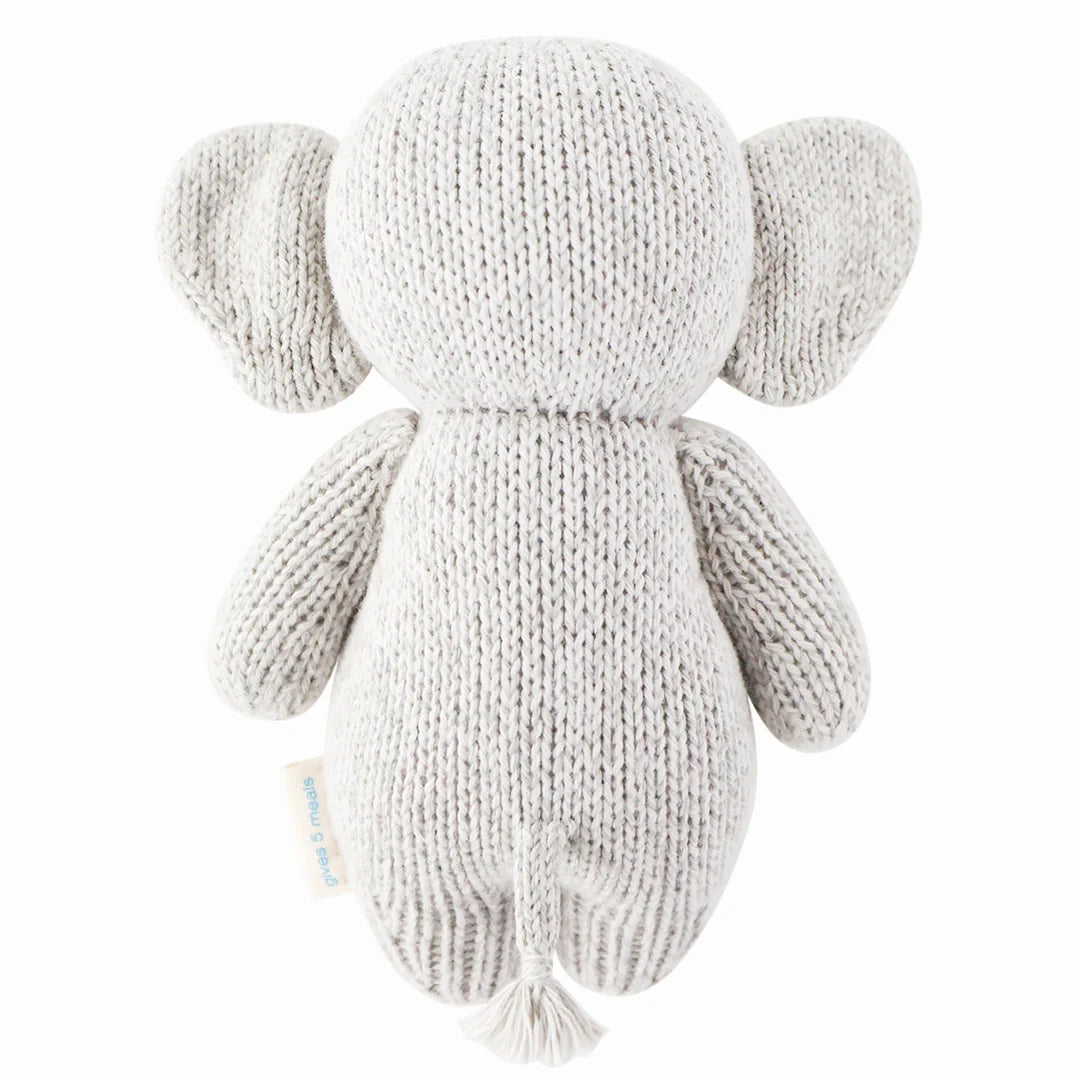 Soft baby elephant plush toy from Cuddle + Kind, showing detailed features and gentle expression on a neutral background.