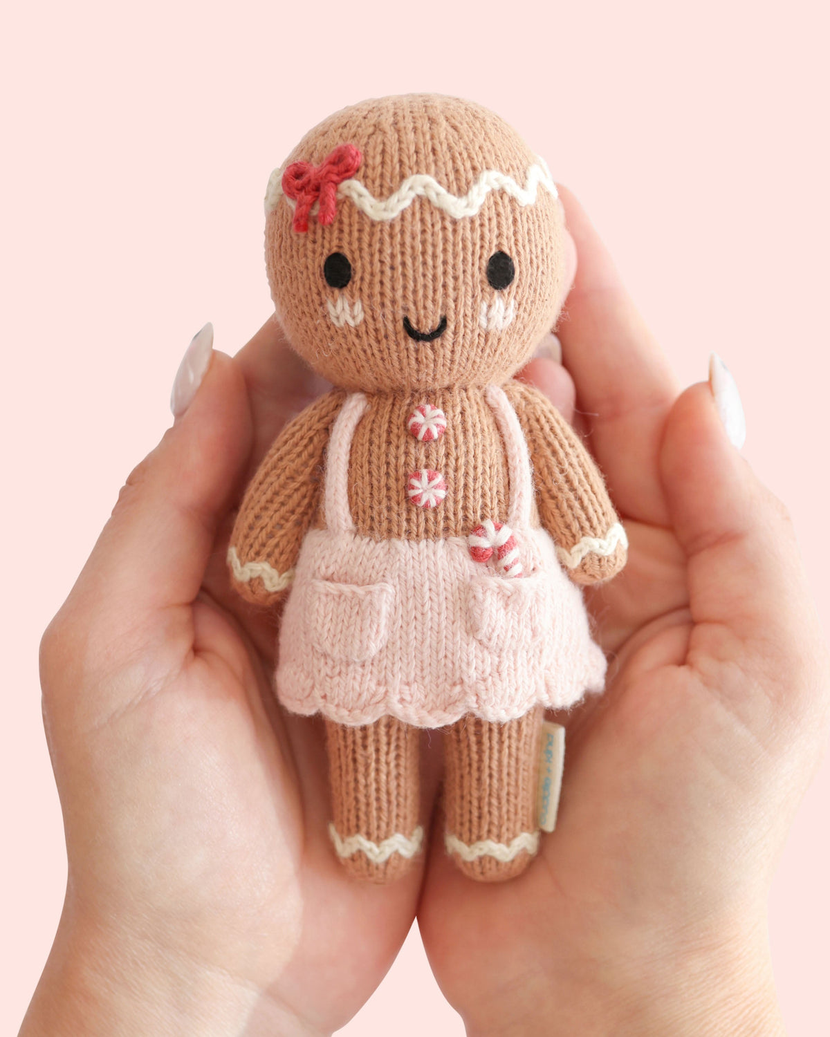 Tiny Gingerbread Sugarplum Girl doll from Cuddle + Kind with soft fabric and detailed gingerbread swirl design, perfect for cuddling.