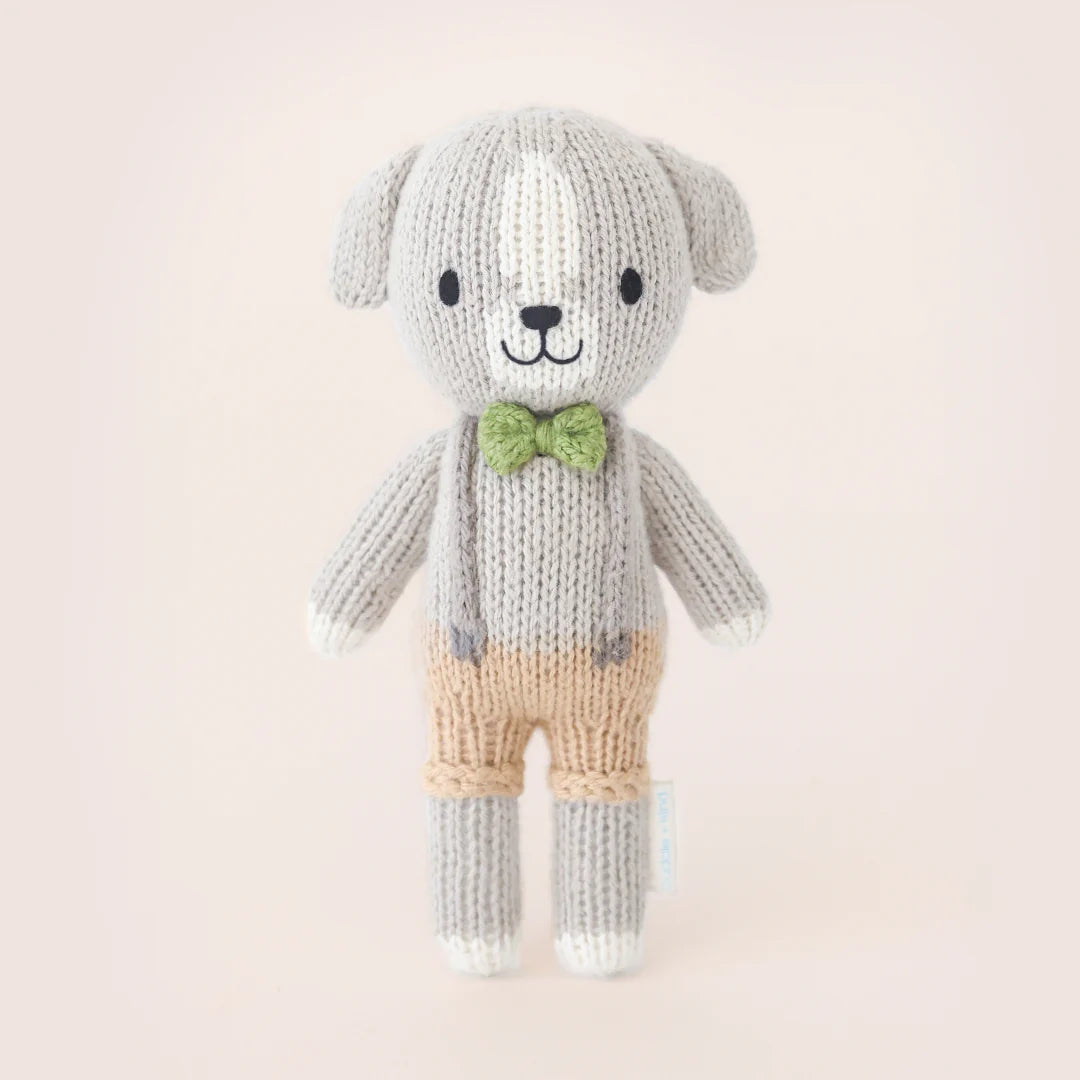 Small plush Tiny Noah the Dog by Cuddle + Kind with soft beige fur and embroidered facial features, ideal for cuddling and gentle play.