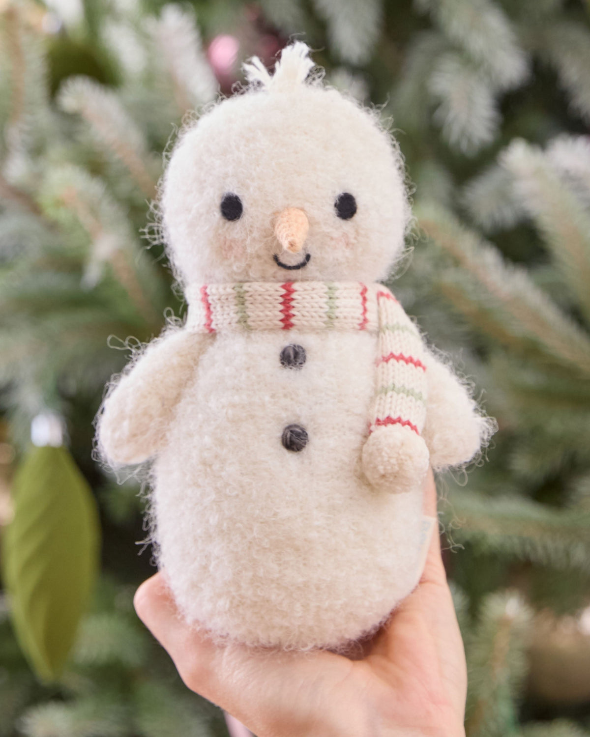 Baby Snowman plush toy with peppermint stripe pattern from Cuddle + Kind, featuring soft fabric and adorable winter-themed design.