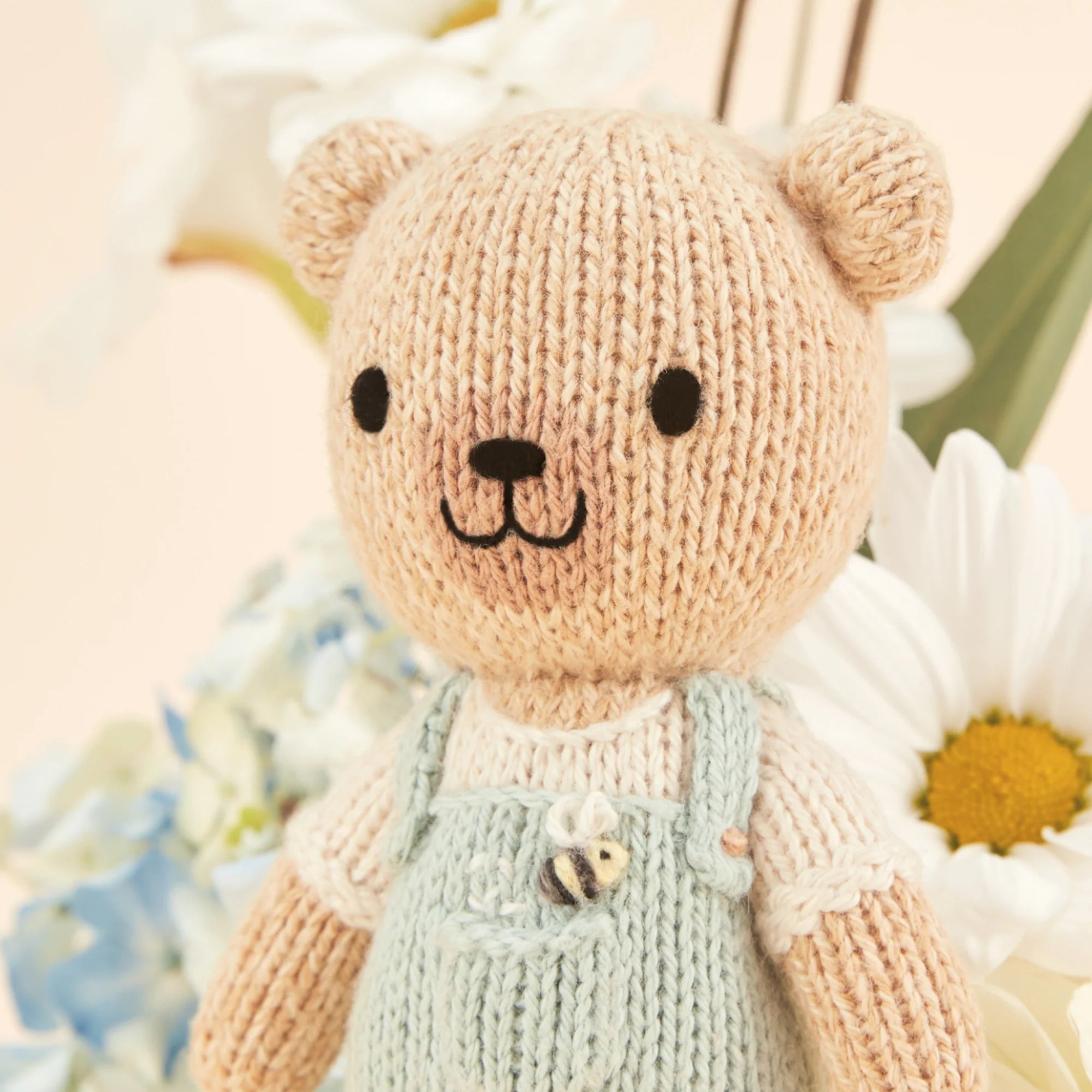 Tiny Charlie the Honey Bear from Cuddle + Kind, a soft plush toy with a honey-colored bear design, perfect for cuddling.