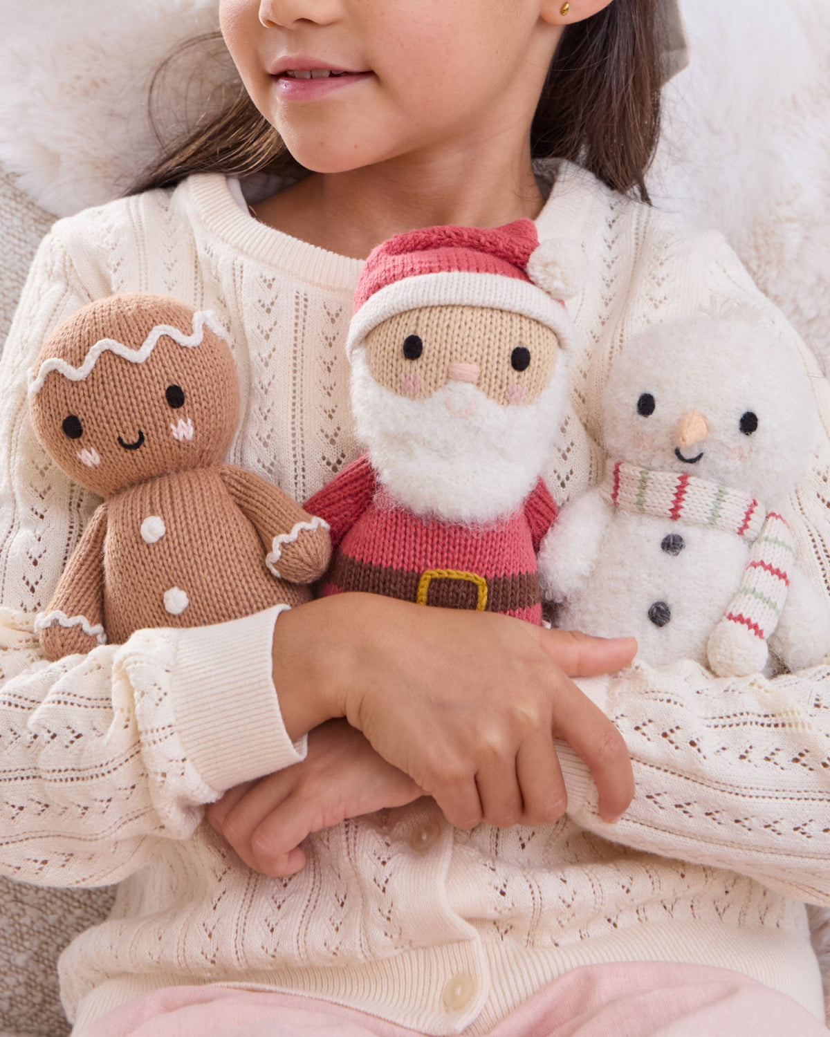 Baby Snowman plush toy with peppermint stripe pattern from Cuddle + Kind, featuring soft fabric and embroidered facial details.