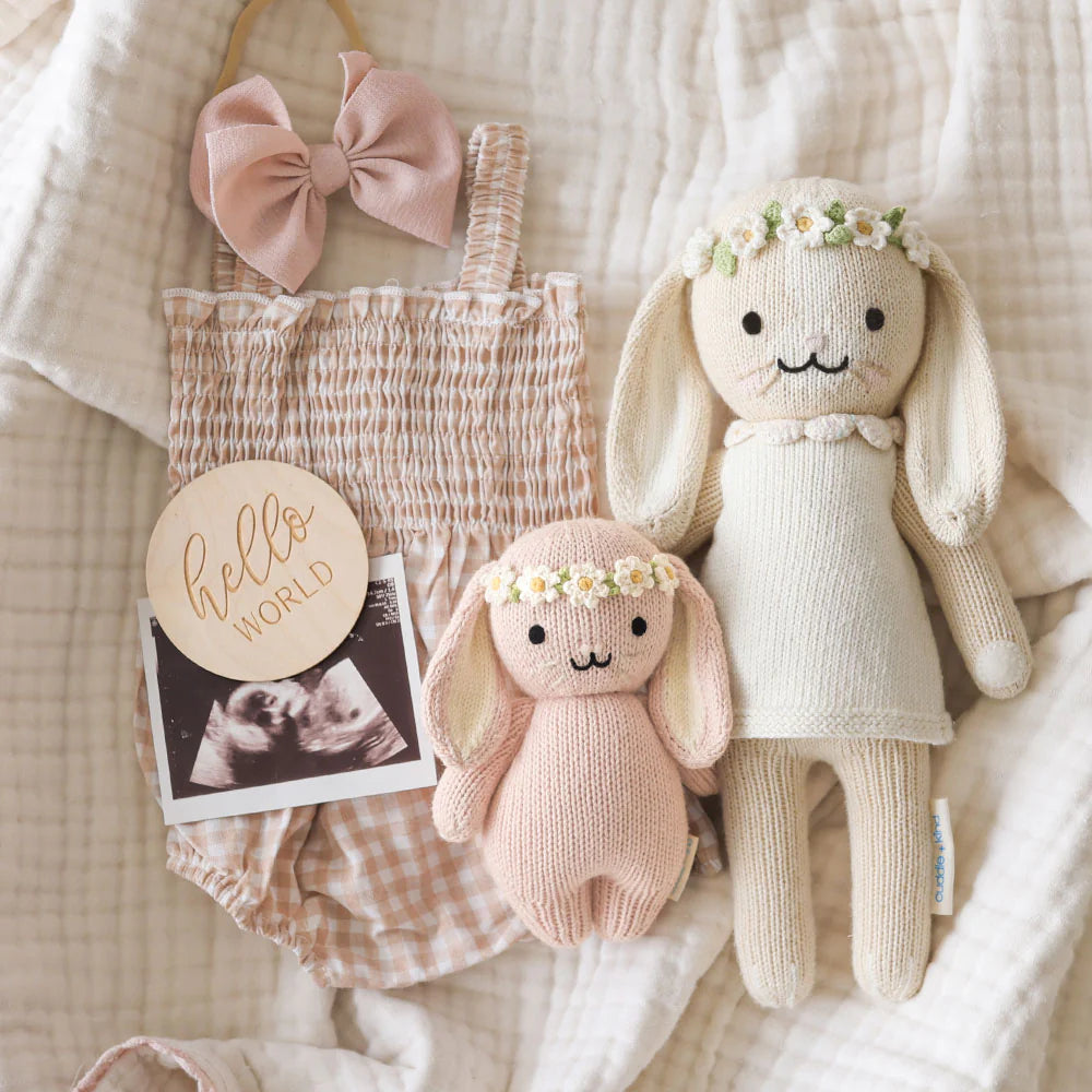 Soft baby bunny doll from Cuddle + Kind with rose and ivory floral details, perfect for gentle cuddles and decorative nursery decor.