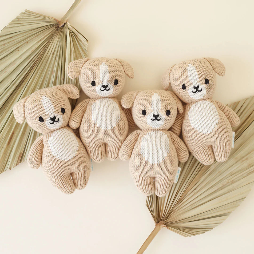 Soft baby puppy toy by Cuddle + Kind featuring plush fabric and adorable puppy design, perfect for comforting and cuddling.