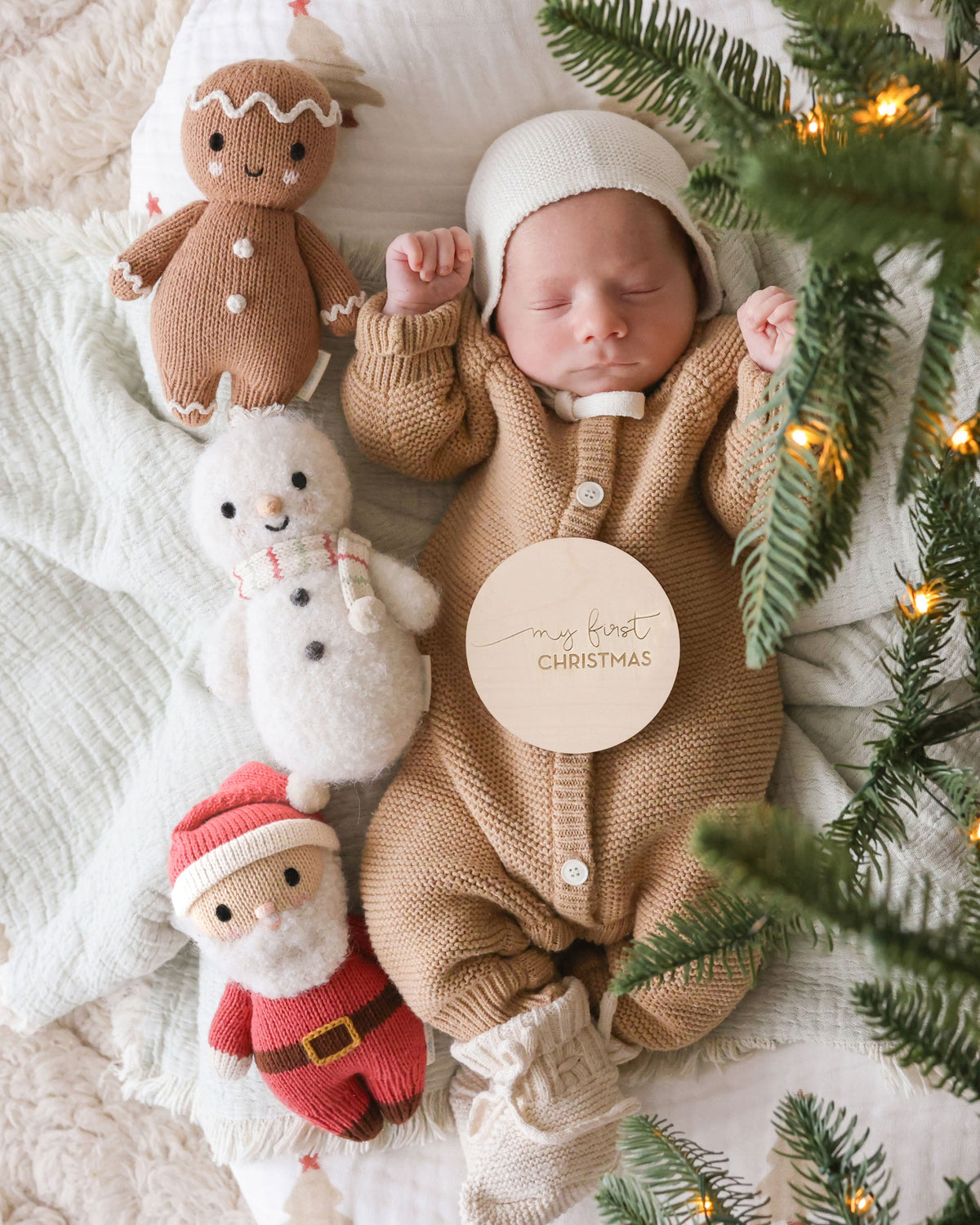Soft Baby Santa doll by Cuddle + Kind with red Santa hat and cozy outfit, perfect for cuddling and holiday decor.
