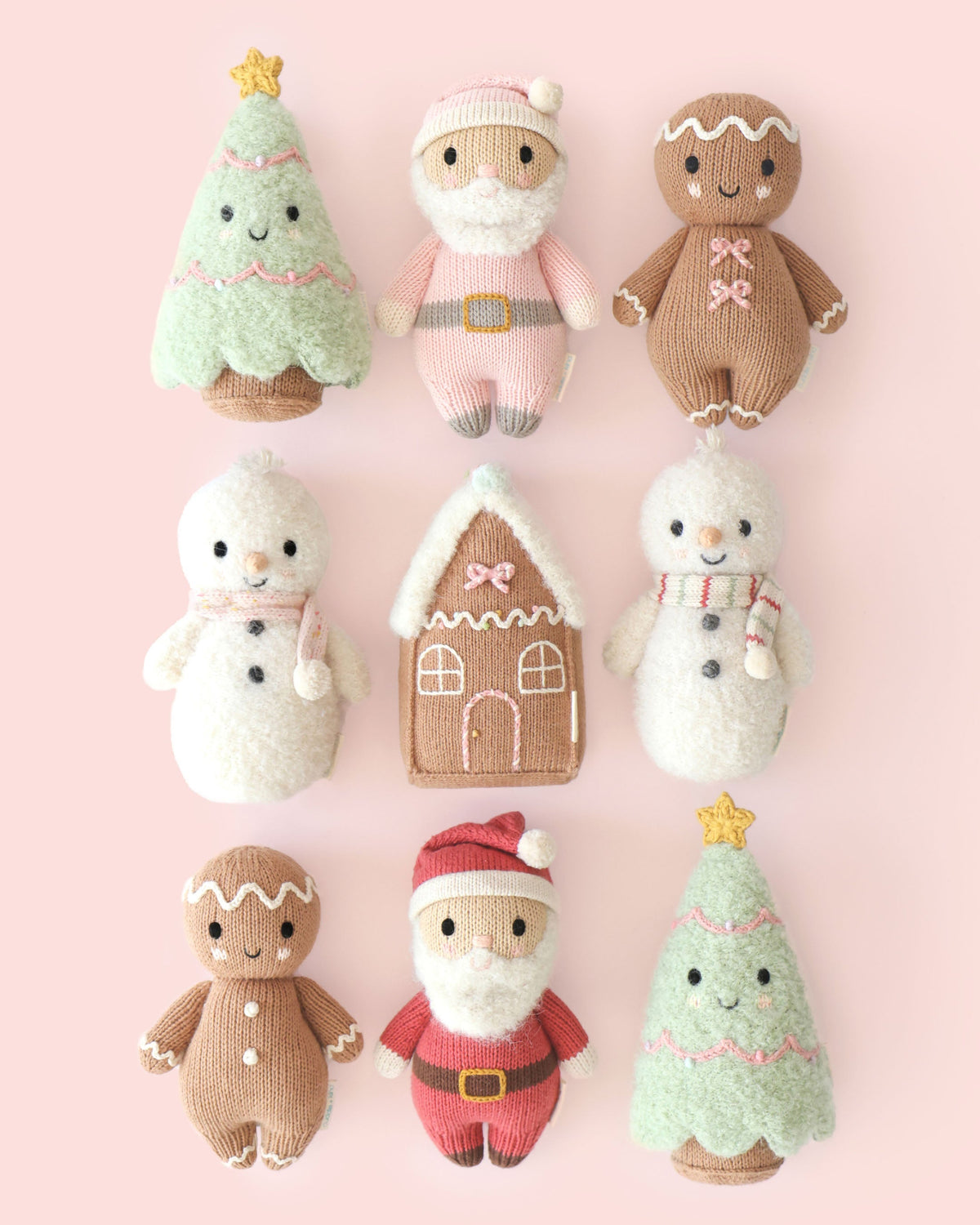 Baby Santa plush toy by Cuddle + Kind with a jolly red outfit, soft fabric, and adorable Santa hat, perfect for cuddling.