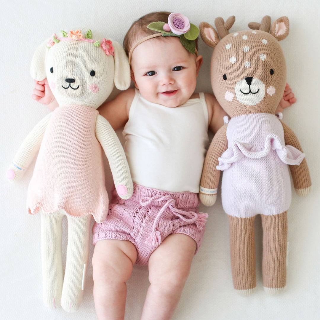 Violet the Fawn and Charlotte the Dog held by a smiling baby - Cuddle + Kind
