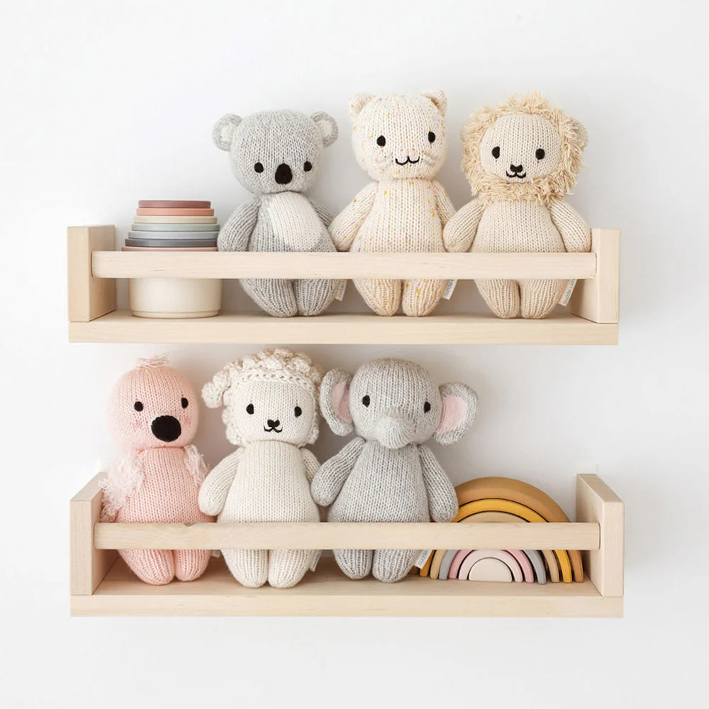 Soft plush baby elephant toy from Cuddle + Kind, featuring a gentle gray body and large floppy ears, perfect for cuddling.
