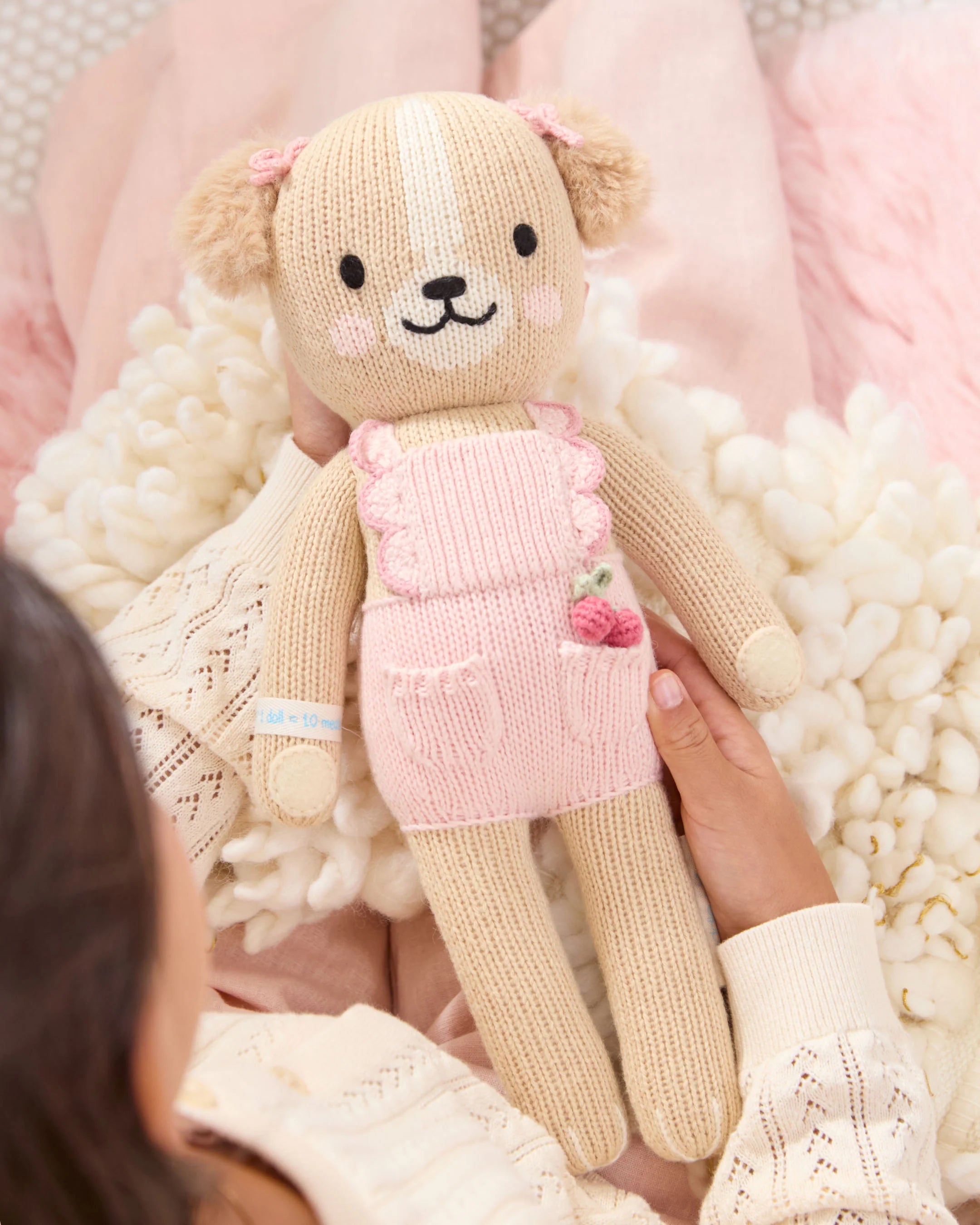 Soft plush golden puppy toy named Nora by Cuddle + Kind, designed for cuddling and comfort, with realistic dog features.