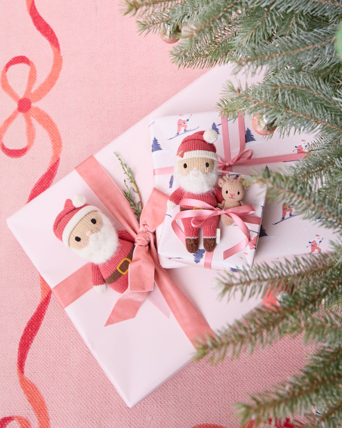 Cute Tiny Santa plush toy from Cuddle + Kind featuring a soft red hat, white trim, and a cheerful Santa face.