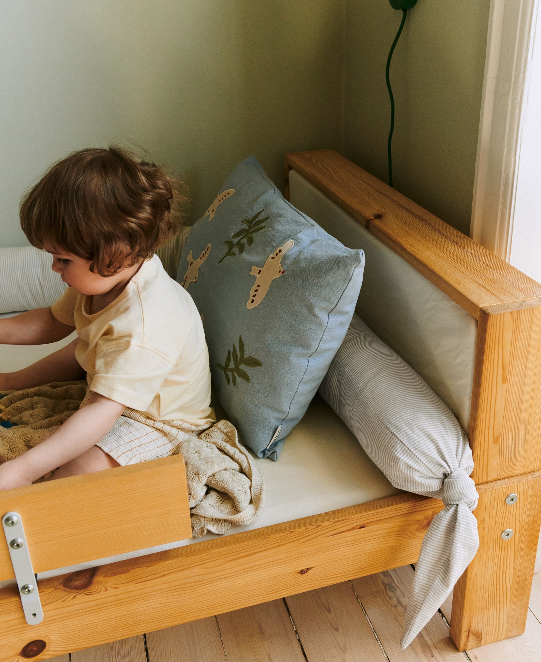 Dear April Skye Bed Snake in Dew Stripe, styled in a cot.