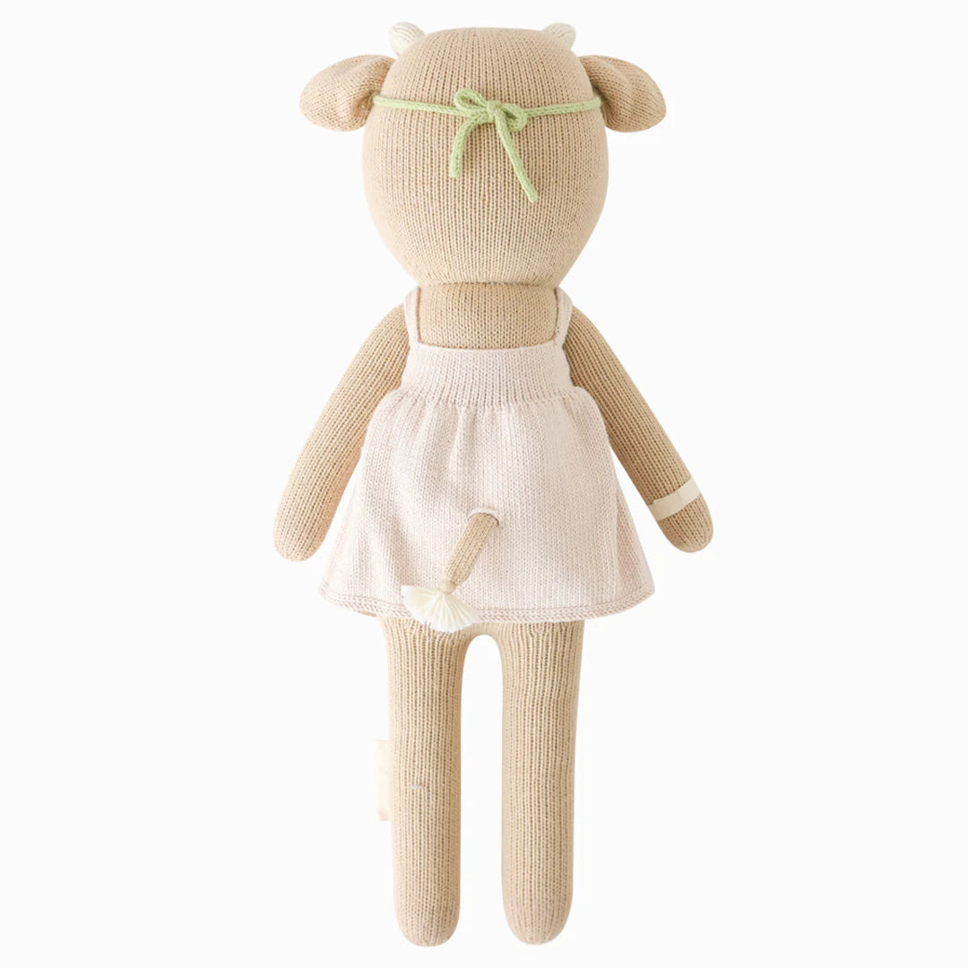 Amelia the Cow plush toy from Cuddle + Kind showing her back with soft, detailed brown and white fur and gentle cow features.