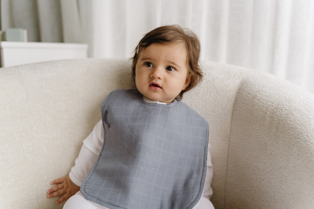 Bubbadue oversized pale blue feeding bib with waterproof material and adjustable neck strap for babies.