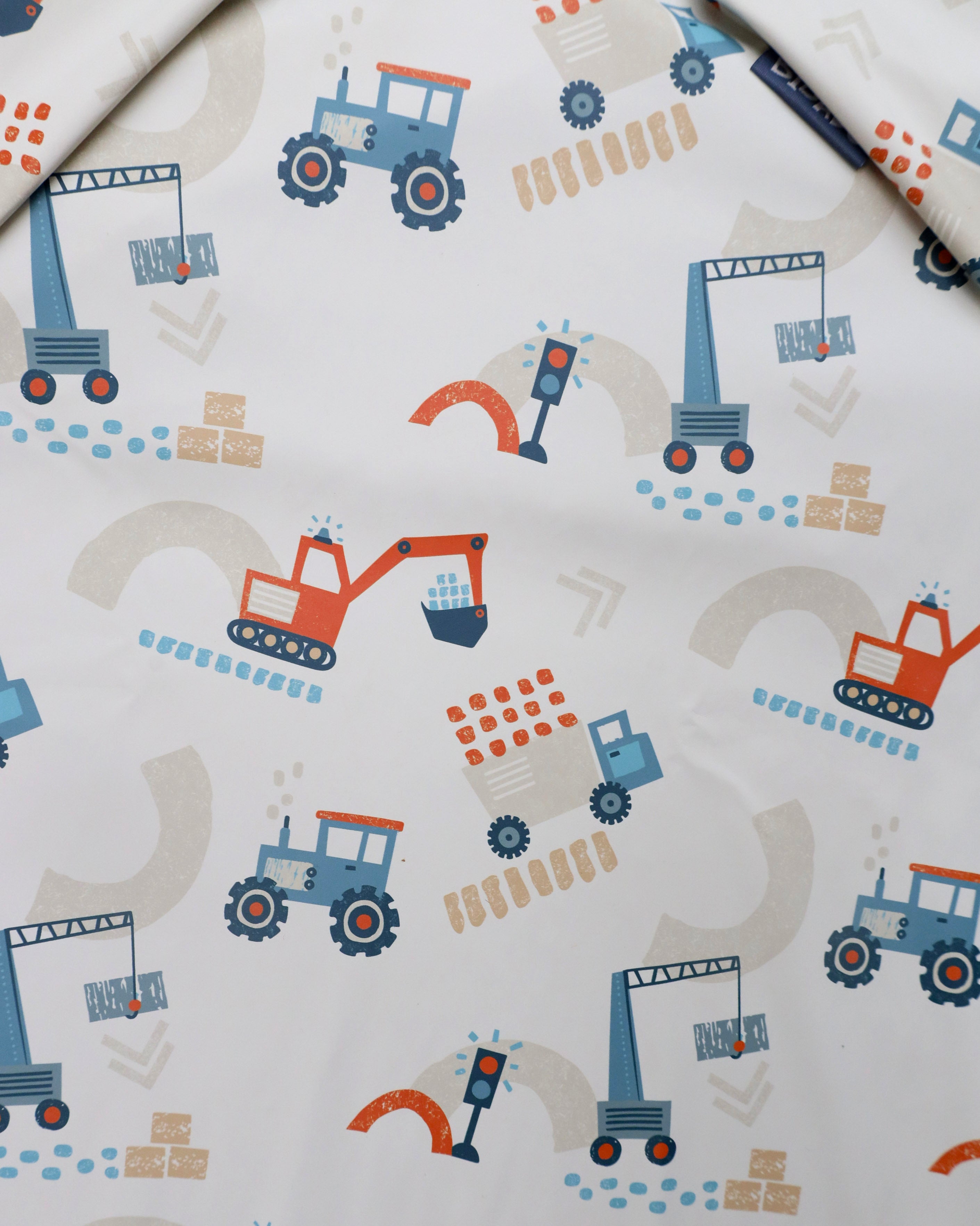 Close-up of Bibado Little Loader Coverall Weaning Bib showing its soft fabric and adjustable straps for messy eating protection.
