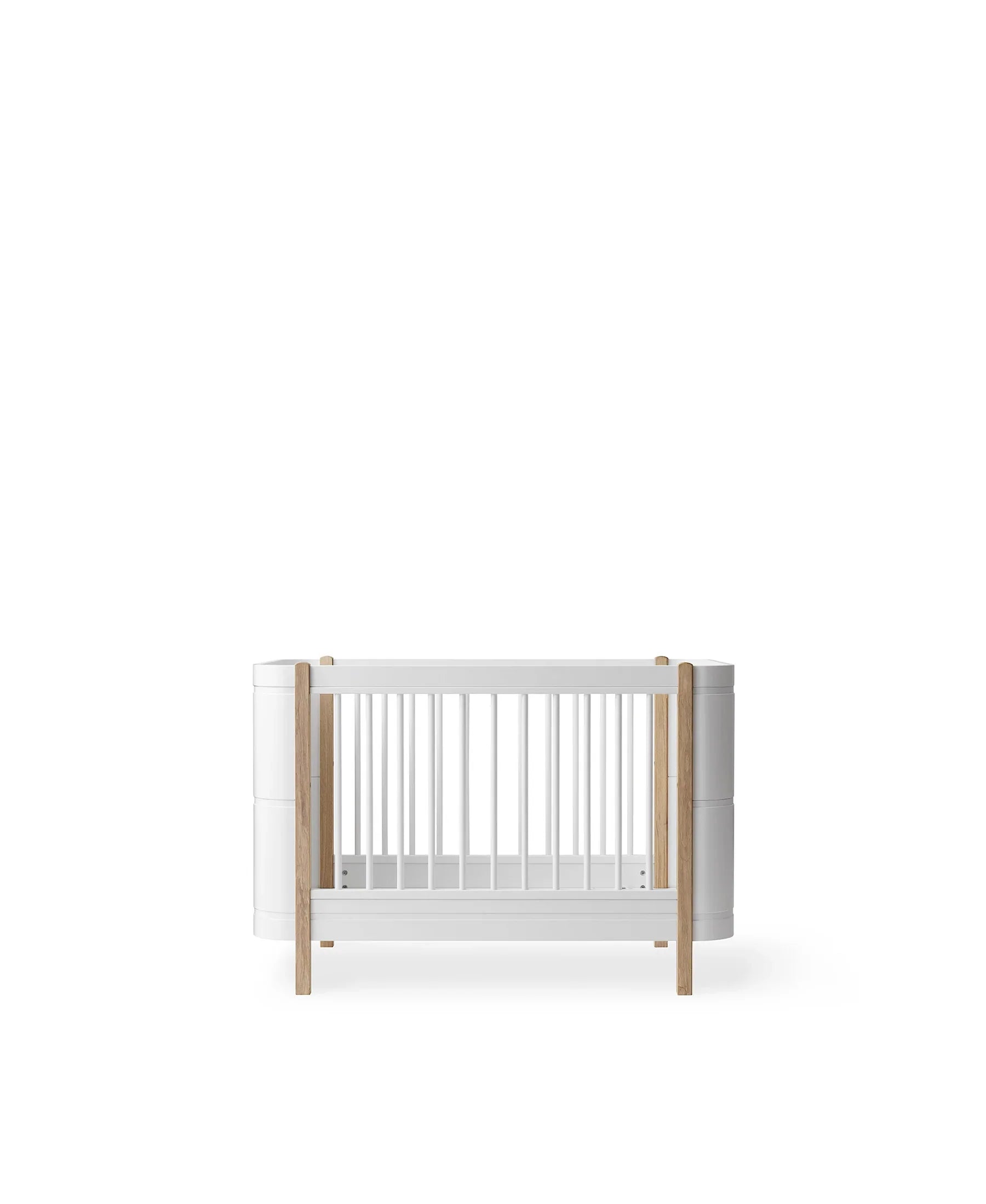 Wood Mini+ cot bed by Oliver Furniture in white and oak, showing a compact, stylish children's bed with wooden slats and a clean finish.