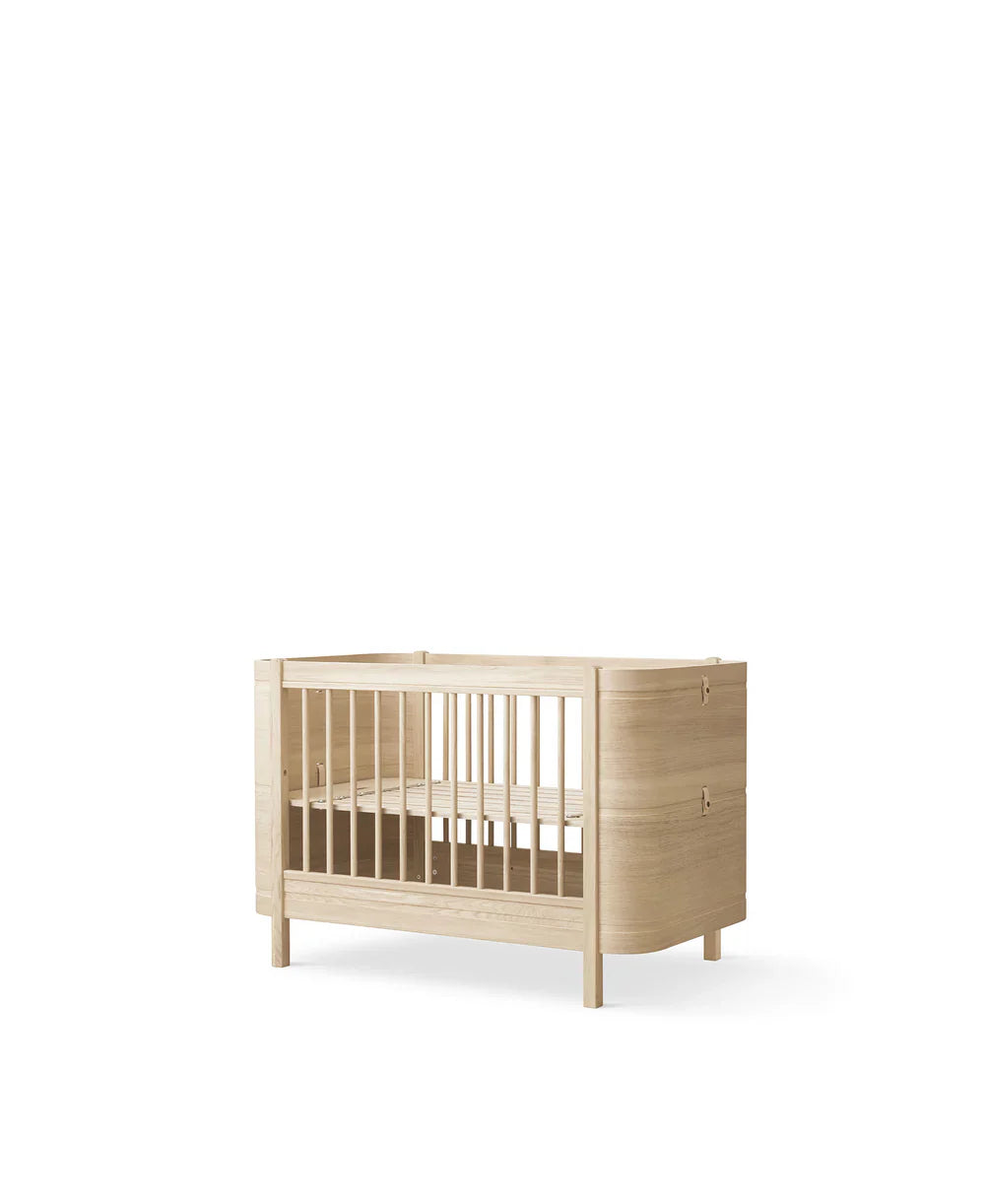 Wood Mini+ Cot Bed in oak with included junior kit, made by Oliver Furniture, shown with smooth wooden finish and sturdy design.