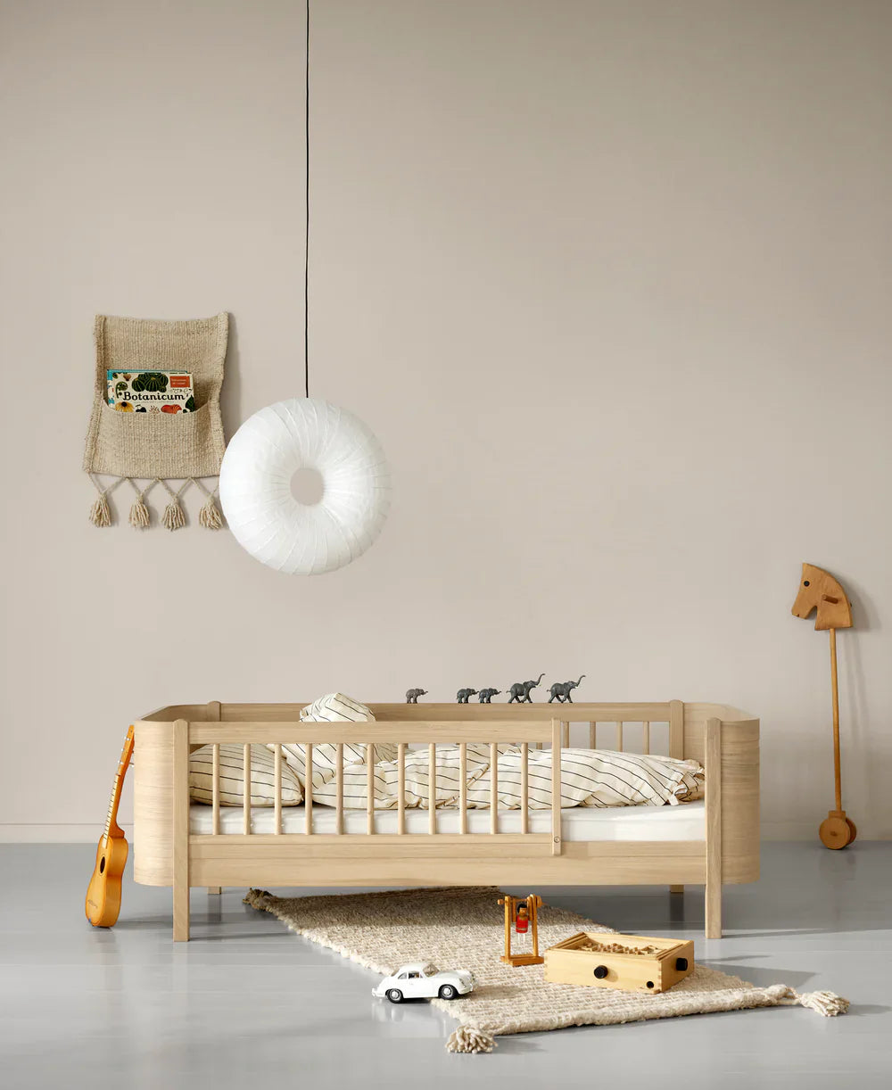 Oliver Furniture Wood Mini+ Cot Bed in white with Junior Kit, a compact and stylish wooden baby bed for nursery use.