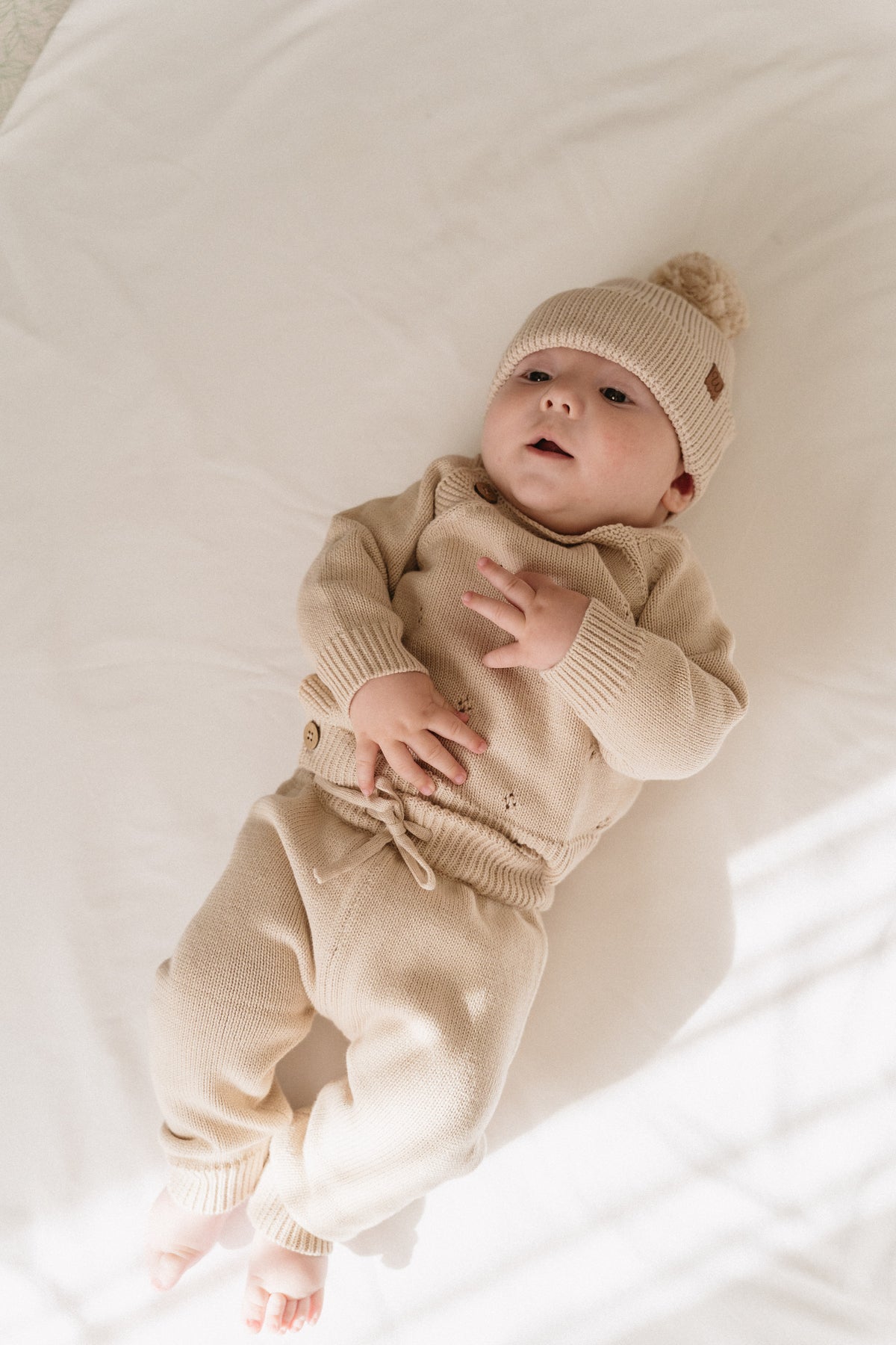 Bubbadue biscuit knitted tracksuit for baby and toddler, soft two-piece outfit displayed flat lay