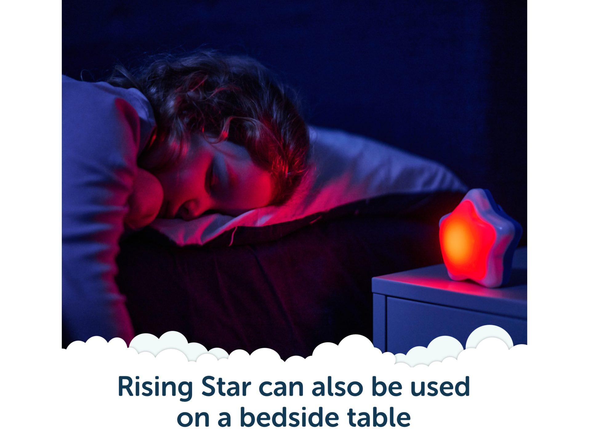 Rising Star used on a bedside table glowing red in a dark bedroom.