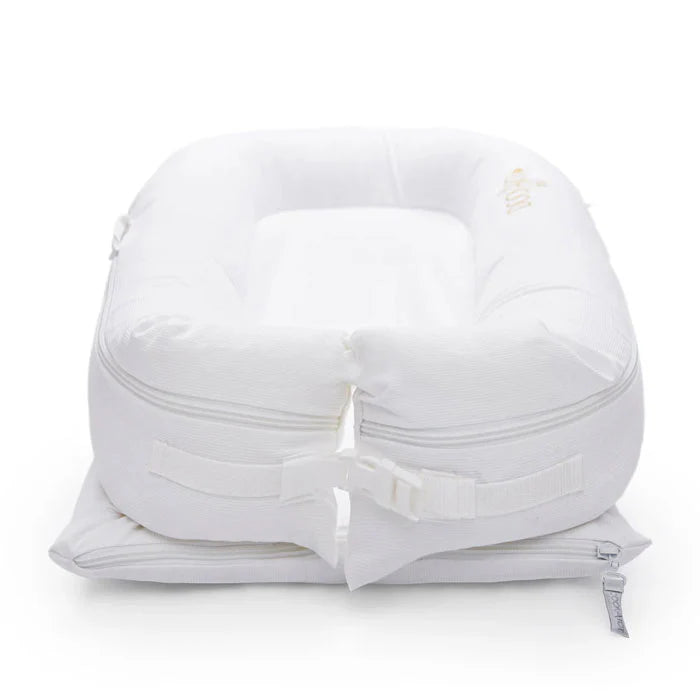 Pristine white Dock-A-Tot Deluxe+ Baby Dock designed for 0-8 months, featuring a soft, cushioned baby sleep and play area.