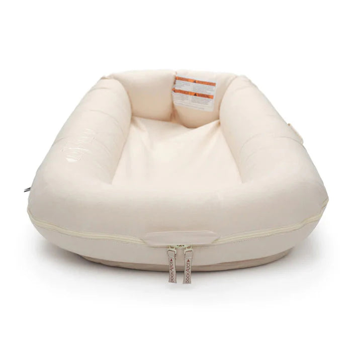 Baby Dock Deluxe+ Dock in Sand Chambray by Dock-A-Tot, showing the soft fabric and cozy design for infants aged 0-8 months.