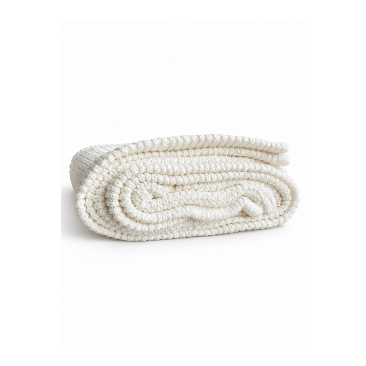 White Bubbadue Whisper weighted knitted blanket draped over a bed, showcasing its soft, cozy texture and handcrafted design.